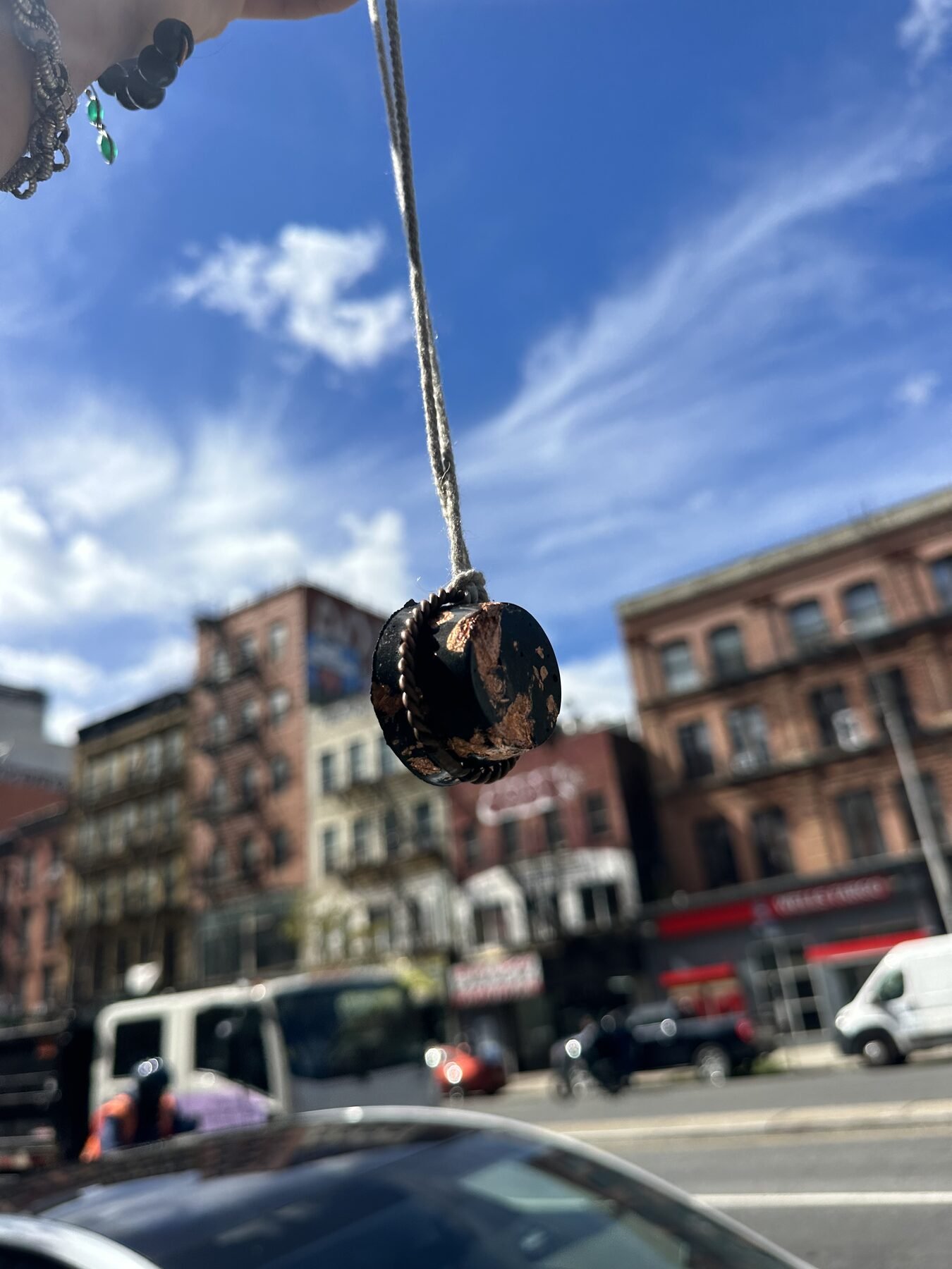 Halo Hanger pendant suspended against a blue sky and city buildings
