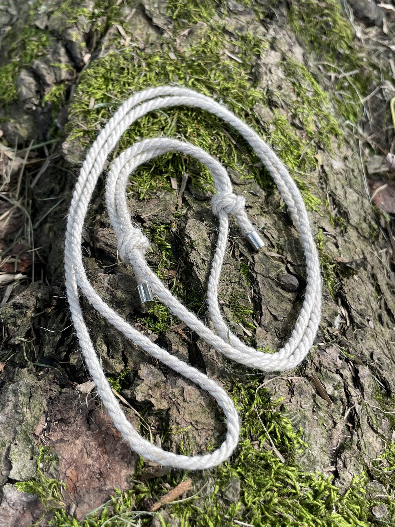 White linen cord for the Halo Hanger arranged on tree bark