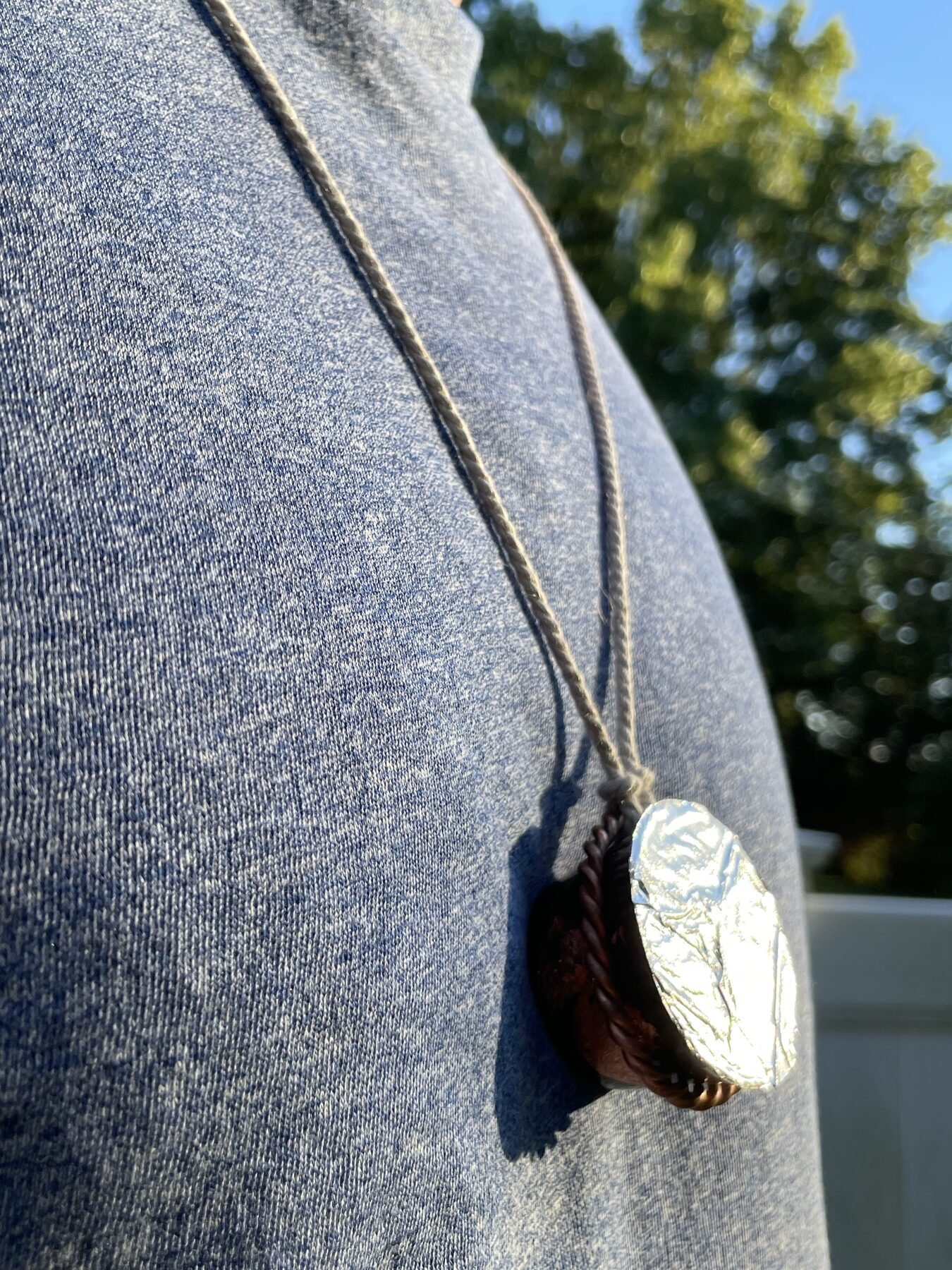Halo Hanger necklace worn over a gray shirt